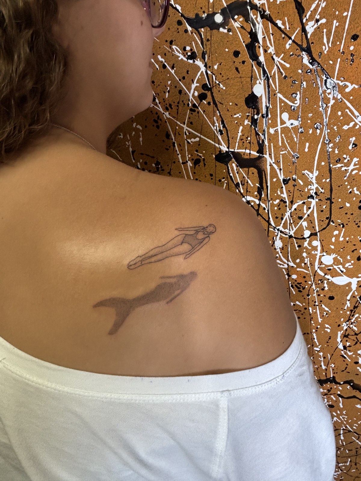 Fine line tattoo of a swimmer and a whale
