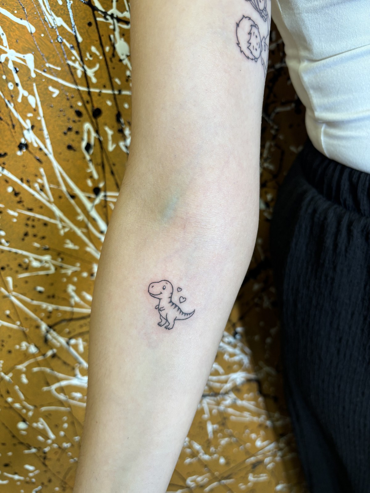 Fine line dinosaur tattoo with hearts